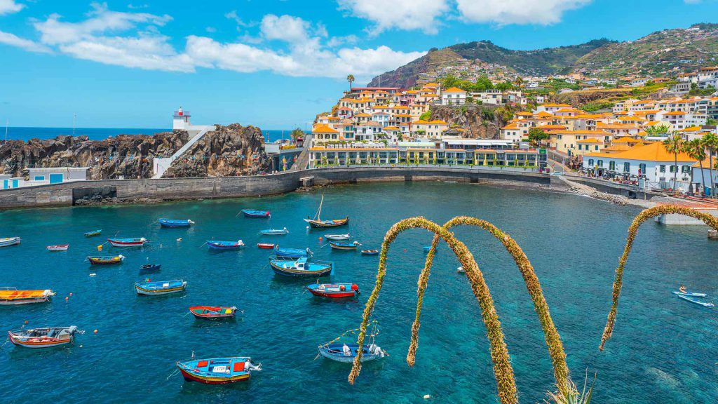 Câmara de Lobos: el pueblo pesquero de Madeira que enamoró a Churchill (y es el 6º Mejor Destino de Europa en 2026) Bahía de Câmara de Lobos con barcos de pesca xavelhas en Madeira