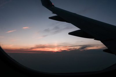 Ala de avión sobre un cielo al atardecer, símbolo de las tendencias de viaje 2026 y la planificación de viajes global